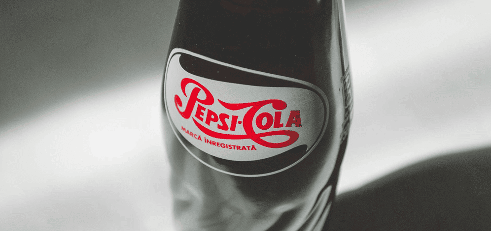 A close-up of a vintage-style glass Pepsi-Cola bottle with a red and white logo and Romanian text on the label.