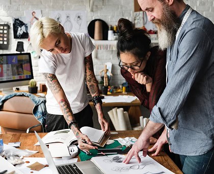 A group of people looking at a drawing on a table.